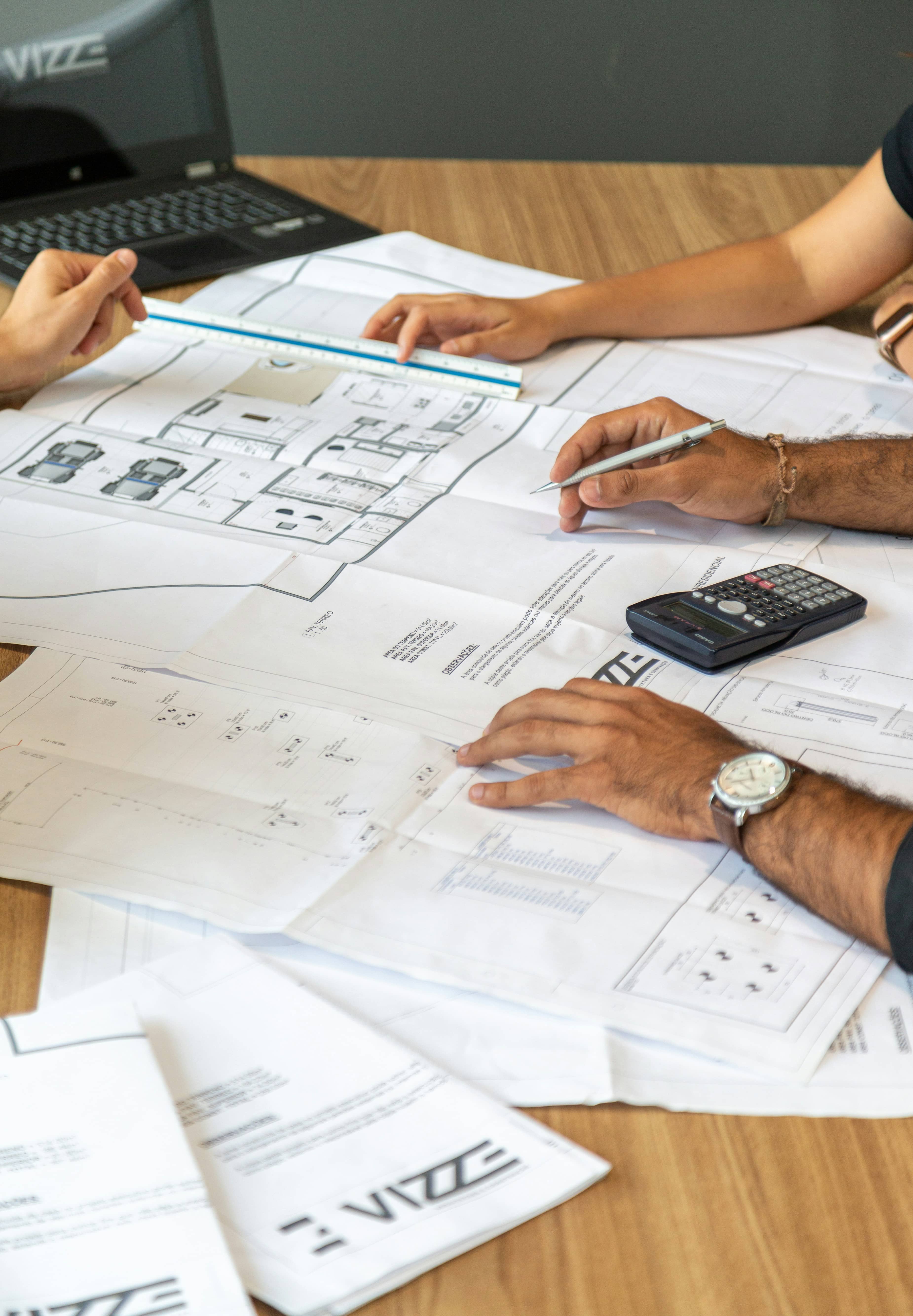 Homeowners and contractor reviewing renovation and extension plans on paper