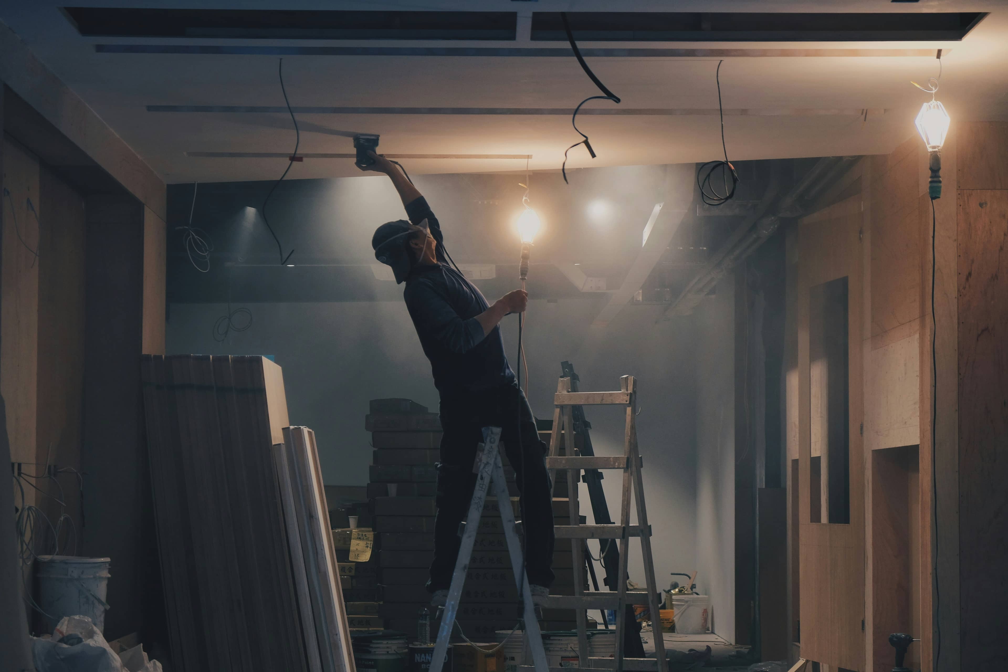 Contractor installing electrical and ceiling fixtures during a home renovation in Johor