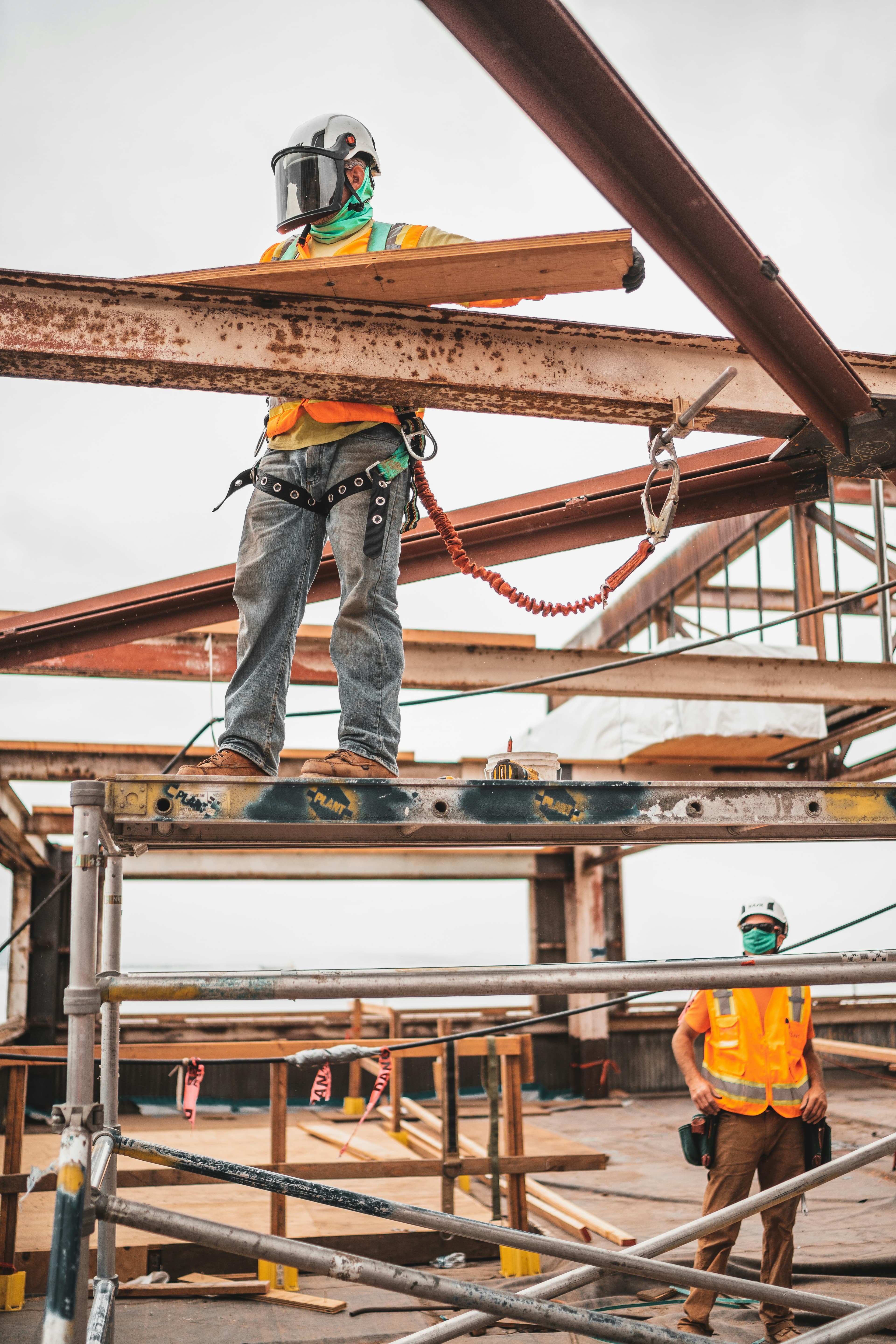 Construction worker securing structural steel beams on a building site in Johor