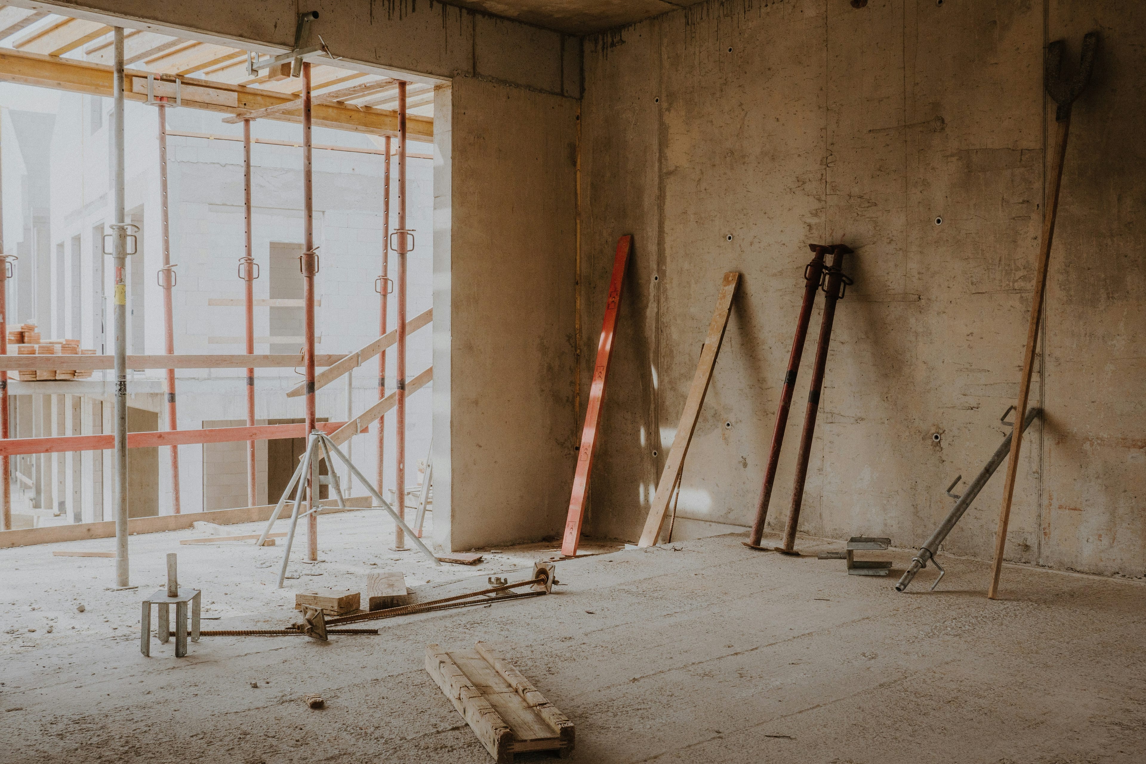 Interior of a building under construction showing exposed structural framing before plumbing fit-out